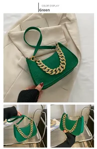 Detail of green faux crocodile leather shoulder bag with a bold gold chain handle