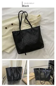 Close-up of black checkered embossed leather tote bag showing detailed texture and long straps