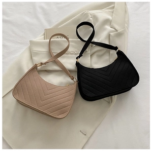 Detail view of V-quilted crescent shoulder bags in black and khaki with adjustable straps
