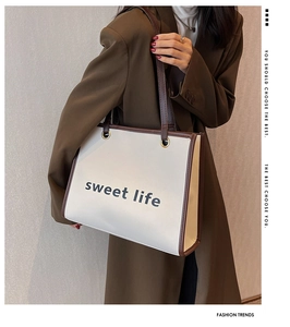 Dettaglio della grande borsa tote con scritte sweet life e manico marrone a contrasto