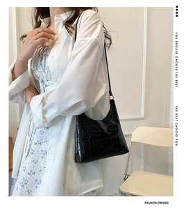 Model showcasing a chic black crocodile texture shoulder bag with a sleek retro design