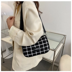 Modella che indossa una borsa sottobraccio in tweed bianco e nero con etichetta Fashion