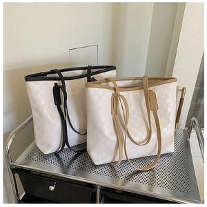 Detail of checkered tote bags in black and brown on a minimalist metal shelf