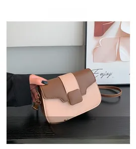 Detail view of two-tone square crossbody bag with adjustable strap and square buckle