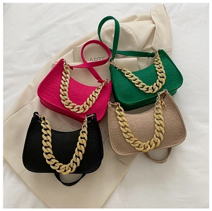 Detail of trendy underarm bags in four colors with crocodile pattern and chunky gold chains