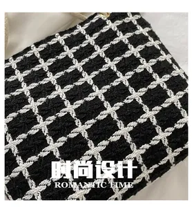 Detail of black and white checkered tweed fabric texture with braided cotton rope handle
