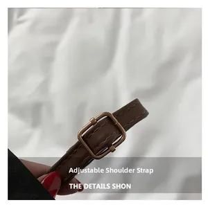 Detail of adjustable dark brown PU leather shoulder strap with bronze metal buckle