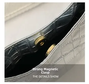 Close-up of silver crocodile embossed handbag with premium gold magnetic buckle detail