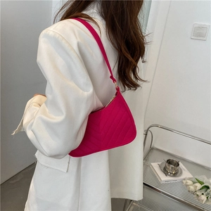 Hot pink chevron quilted crescent shoulder bag shown on model with minimalist background