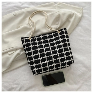 Detail of tweed checkered tote bag with rope handles and smartphone for size reference