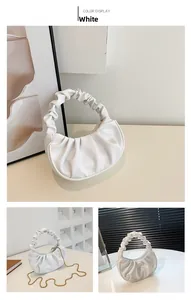 Macro shot of white pleated cloud bag with golden chain strap and soft leather texture