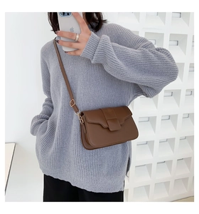 Brown leather square shoulder bag shown on model with minimalist magnetic flap closure