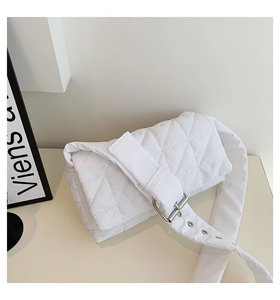 Detail of white quilted puffy shoulder bag with wide strap and silver metal buckle adjustment
