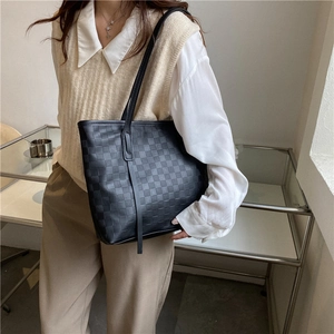 Classic black checkerboard tote bag with minimalist leather straps and vertical trim