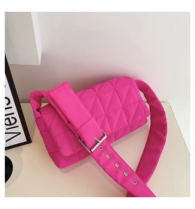 Detailed quilted texture of neon pink padded shoulder bag with oversized buckle and eyelets