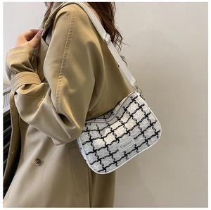 Dettaglio della borsa a tracolla in tweed a scacchi con tracolla regolabile su trench