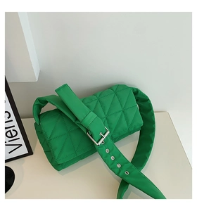 Detail of bright green quilted shoulder bag with diamond pattern and silver metal buckle
