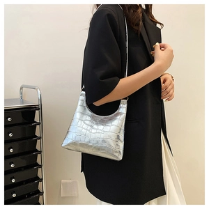 Close-up of silver crocodile embossed shoulder bag with polished metallic finish