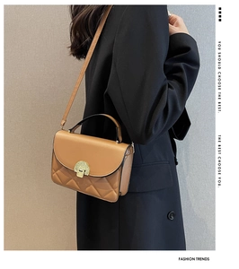 Detail of caramel crossbody bag with vintage gold lock and mixed quilted texture