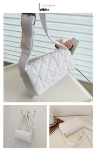 Detailed view of white quilted cotton shoulder bag with wide strap and silver buckles