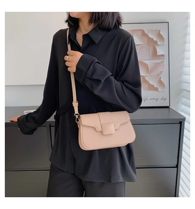 Detail of minimalist beige leather crossbody bag with metal buckle and adjustable strap