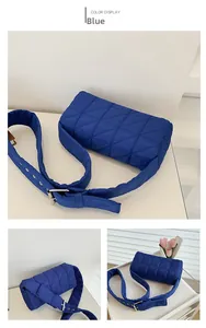 Detail of blue quilted shoulder bag featuring soft puffer texture and adjustable strap