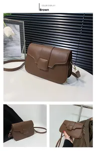 Detail of vintage brown square crossbody bag featuring matte leather and a square buckle