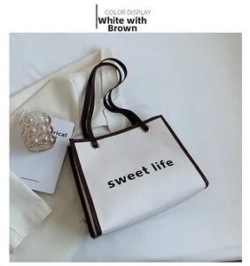Dettaglio della borsa tote bianca con scritta sweet life e tracolla marrone scuro