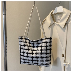 Close-up of black and white plaid tweed tote bag with woven rope shoulder straps