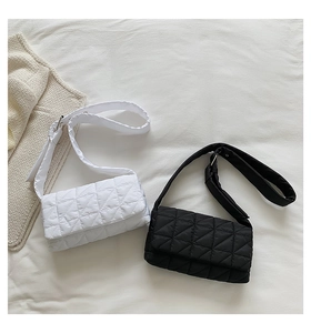 Detail of quilted puffer shoulder bag with adjustable wide strap and metallic buckle