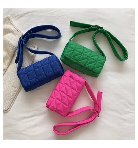 Detailed flat lay of quilted nylon pillow bags in electric blue, green, and rose pink tones