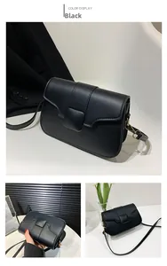 Close-up of black crossbody square bag with matte leather and golden metal hooks
