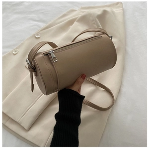 Top-down view of cream cylindrical crossbody bag with silver hardware and smooth leather