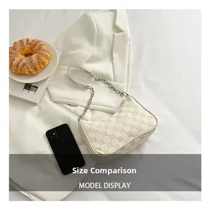 Size comparison of the cream checkerboard canvas shoulder bag with a smartphone