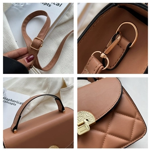 Detail view of brown quilted bag showing golden hardware and adjustable leather strap
