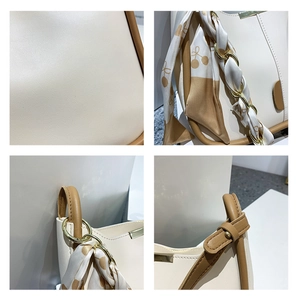 Détails du sac seau crème avec bordure caramel, foulard cerise et anse en chaîne