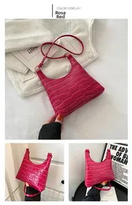 Detail view of the rose red crocodile embossed pattern and texture on this handbag