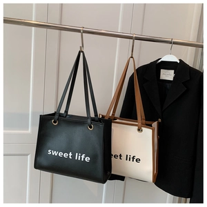 Dettaglio delle borse tote con stampa Sweet Life in ecopelle nera e beige con manici