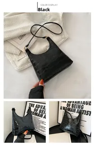 Detailed macro view of black crocodile embossed shoulder bag with gold metal ring buckle
