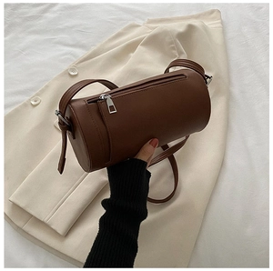 Detail view of brown cylindrical bag with fine leather texture and silver zipper