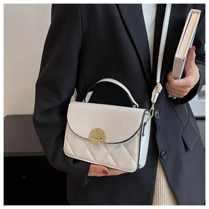 Chic white crossbody bag with gold clasp and quilted pattern shown on black blazer