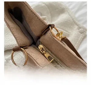 Detailed close-up of premium golden metal zipper on a brown suede tote bag