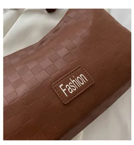 Close-up of brown PU leather shoulder bag featuring checkered texture and Fashion label
