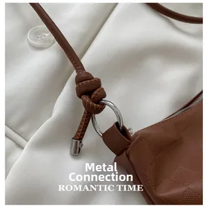 Macro view of brown textured leather bag with silver metal ring and knotted strap detail