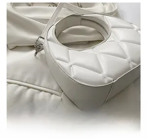 Detailed macro of white quilted faux leather purse with triangle geometric stitching