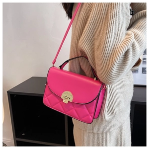 Model wearing a stylish rose red quilted PU leather crossbody bag with golden clasp