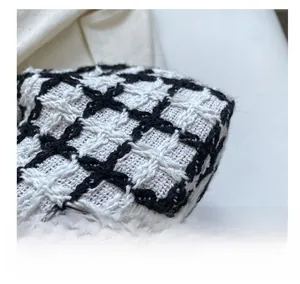 Detailed macro shot of high-quality black and white tweed fabric with textured weave