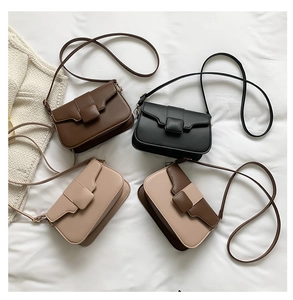 Flat lay of vintage square crossbody bags in coffee, black, and beige leather variants