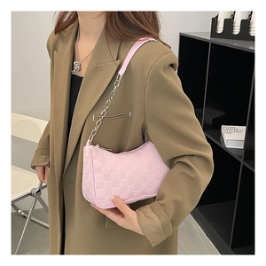 Detail of pink plaid plush hobo bag with silver chain strap worn by a model