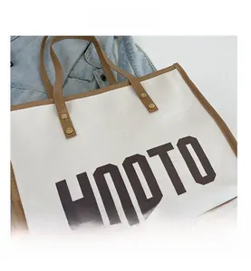 Détails du sac cabas HOOTO en toile avec bordure en cuir marron et lettrage imprimé